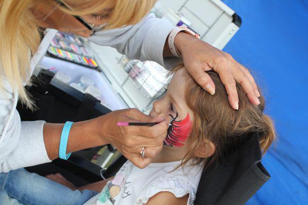 Photo of a child getting her face Painted.