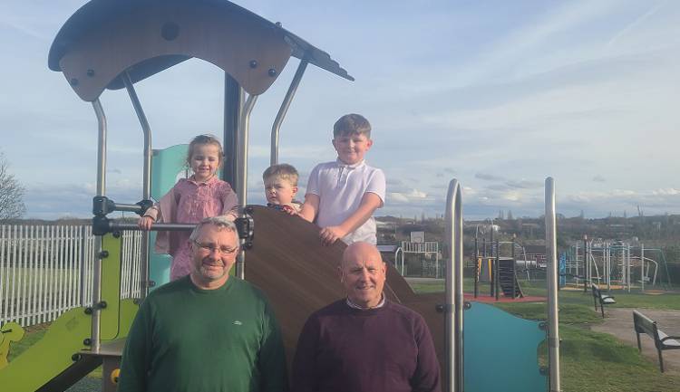 Photo of Cllr Andy Burgin and council parks development officer Andy Chambers with children at Queensway Park play area