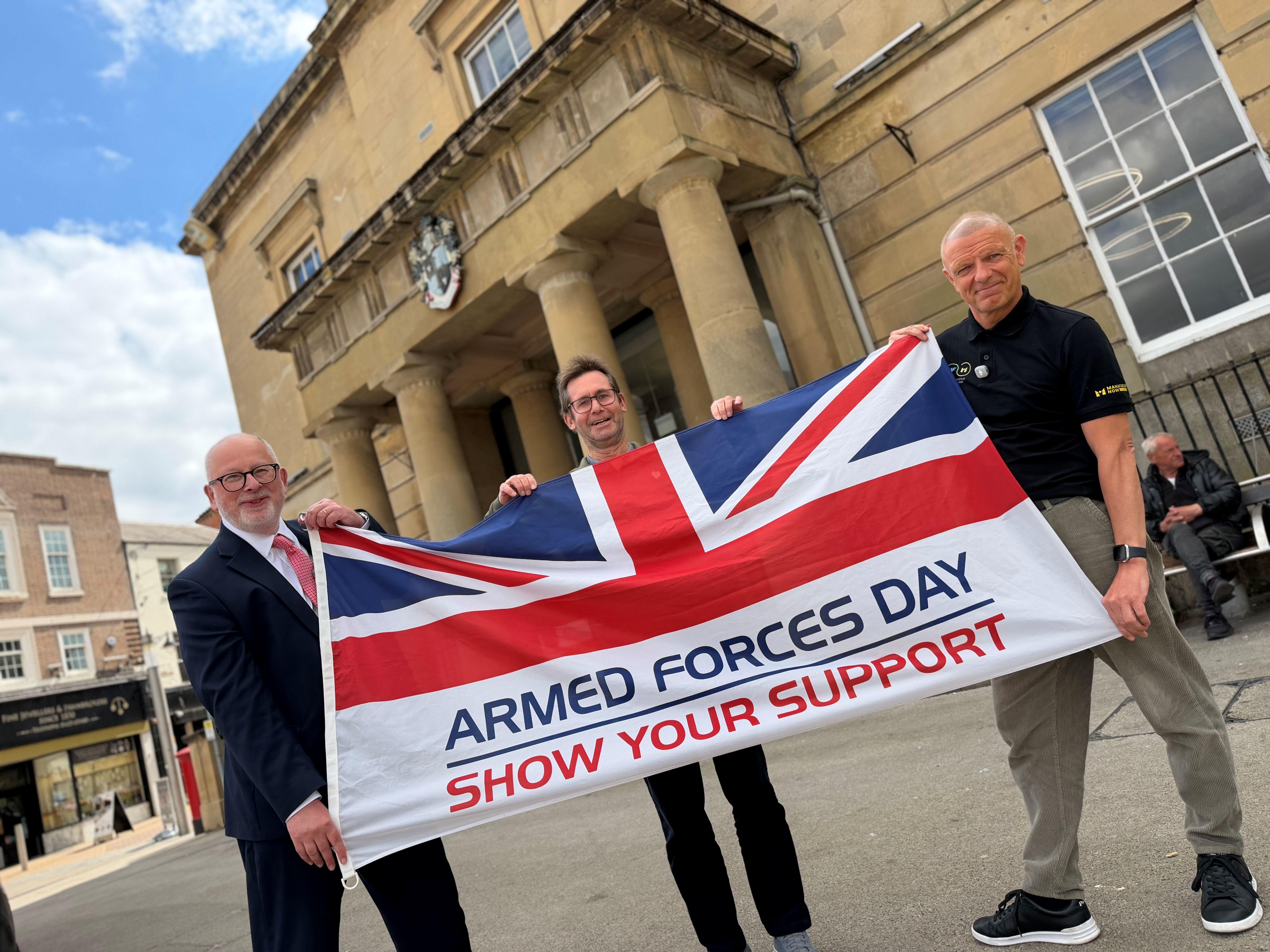 Steve Yemm, Mayor and Jay holding armed forces flag outside the town hall