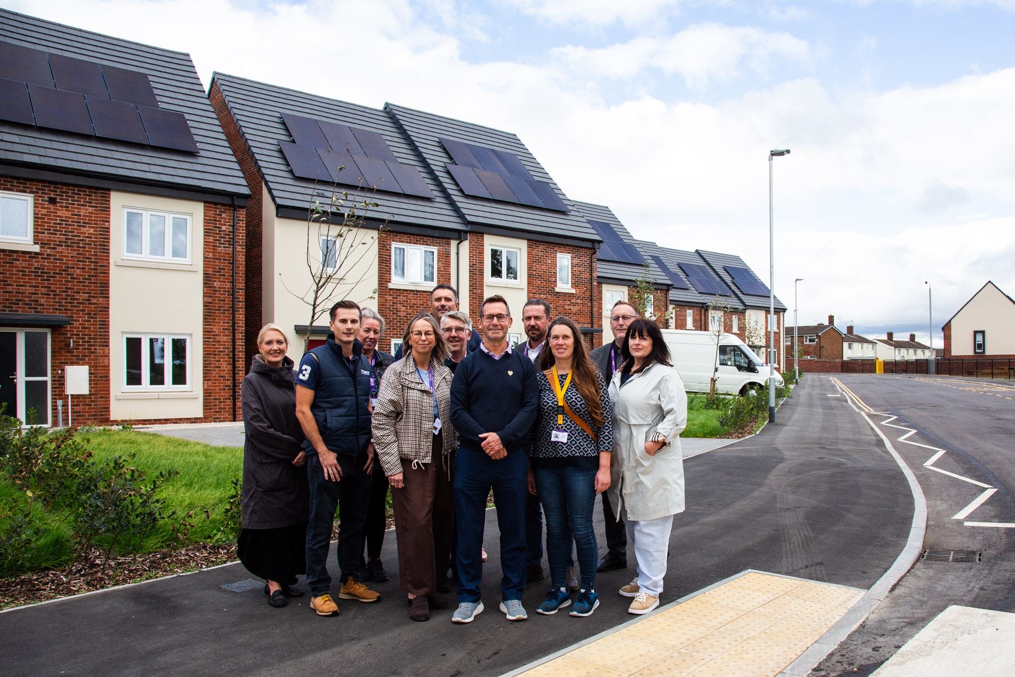 Mayor Andy Abrahams celebrates the new homes with people from Mansfield District Council and Mercer Building Contractors outside the new homes