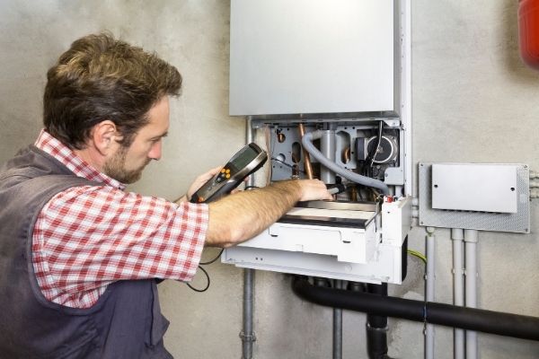 A photo of a man working on a boiler