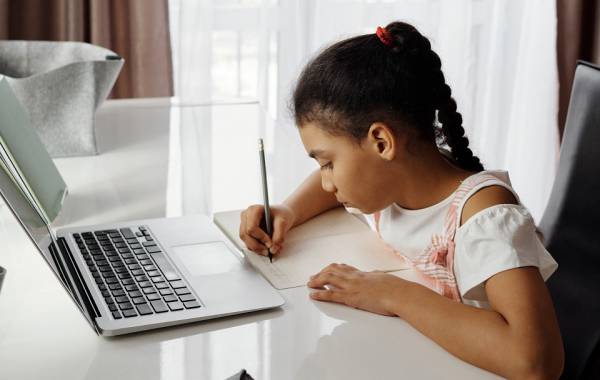 Image of a child doing her homework on a laptop