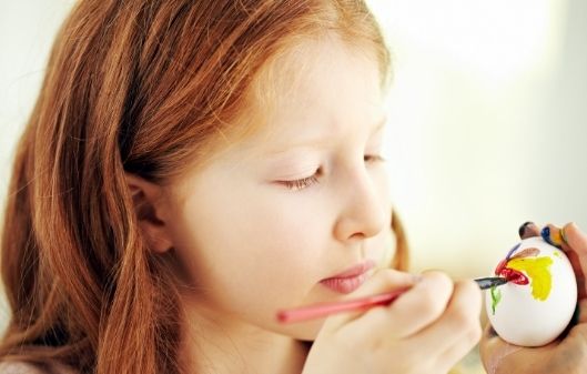 Girl painting an egg