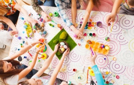 Children painting eggs for Easter