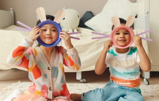 Two young boys with Easter bunny ears and whiskers on a play mask.