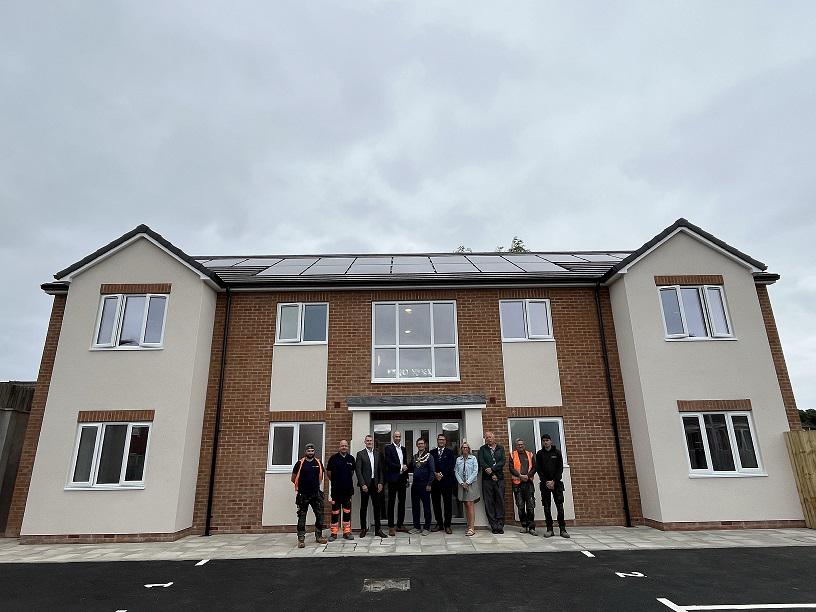 A picture showing the new flats in Fritchley Court with the builders, Mayor, Chief Executive and council officers stood outside by the front doors