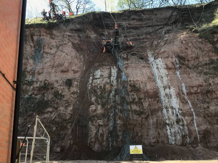 Workers abseil down the cliff face to drill nails into the soil at the former Berry Hill Quarry