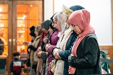 Muslim women standing in silence during prayers at Mansfield Museum