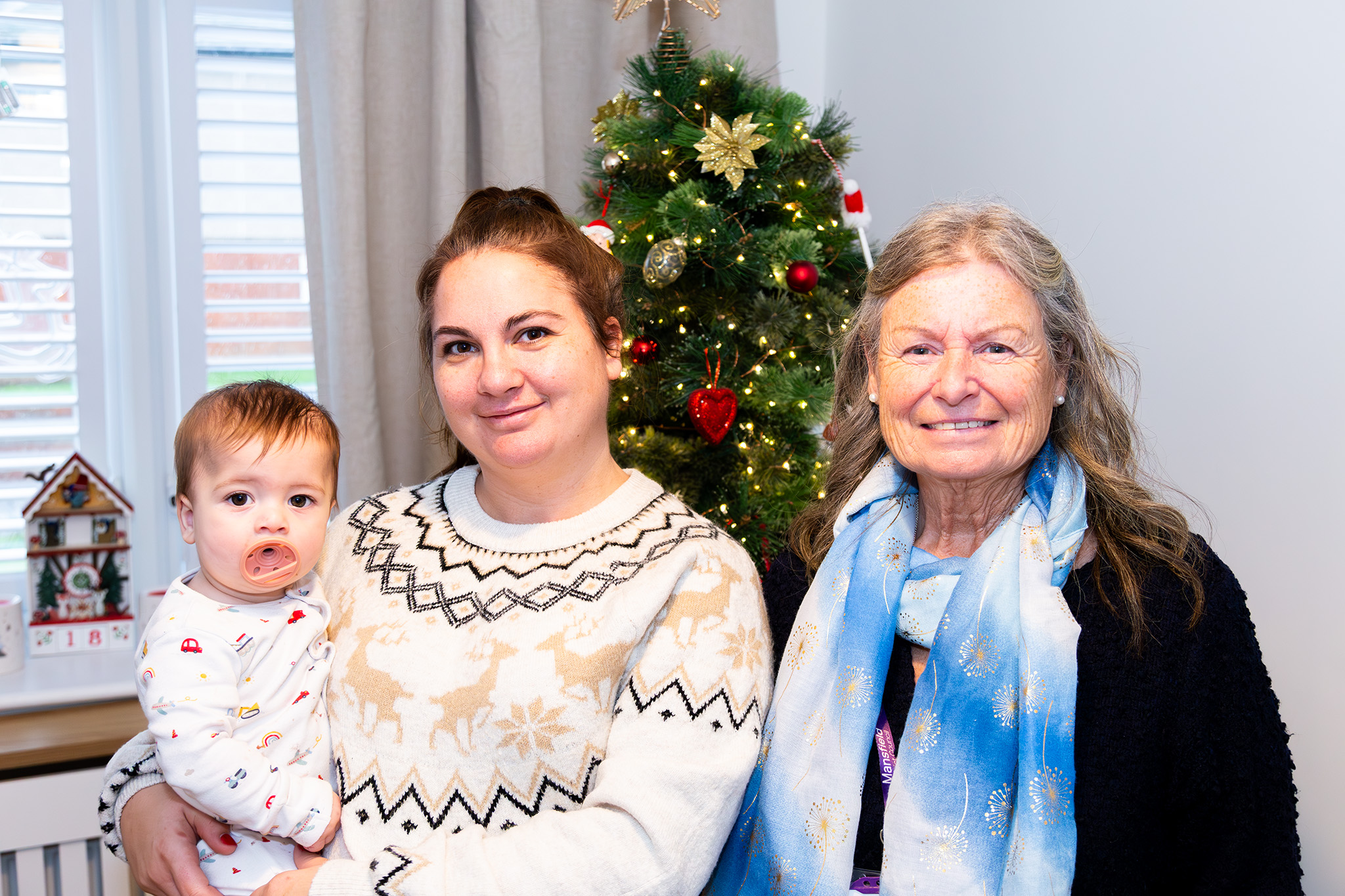Laura and Luca Parkin standing in front of a Christmas tree with Cllr Callaghan