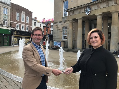 Photo of Executive Mayor Andy Abrahams presenting Jenna Simpson with the keys to her new salon at Mansfield Old Town Hall