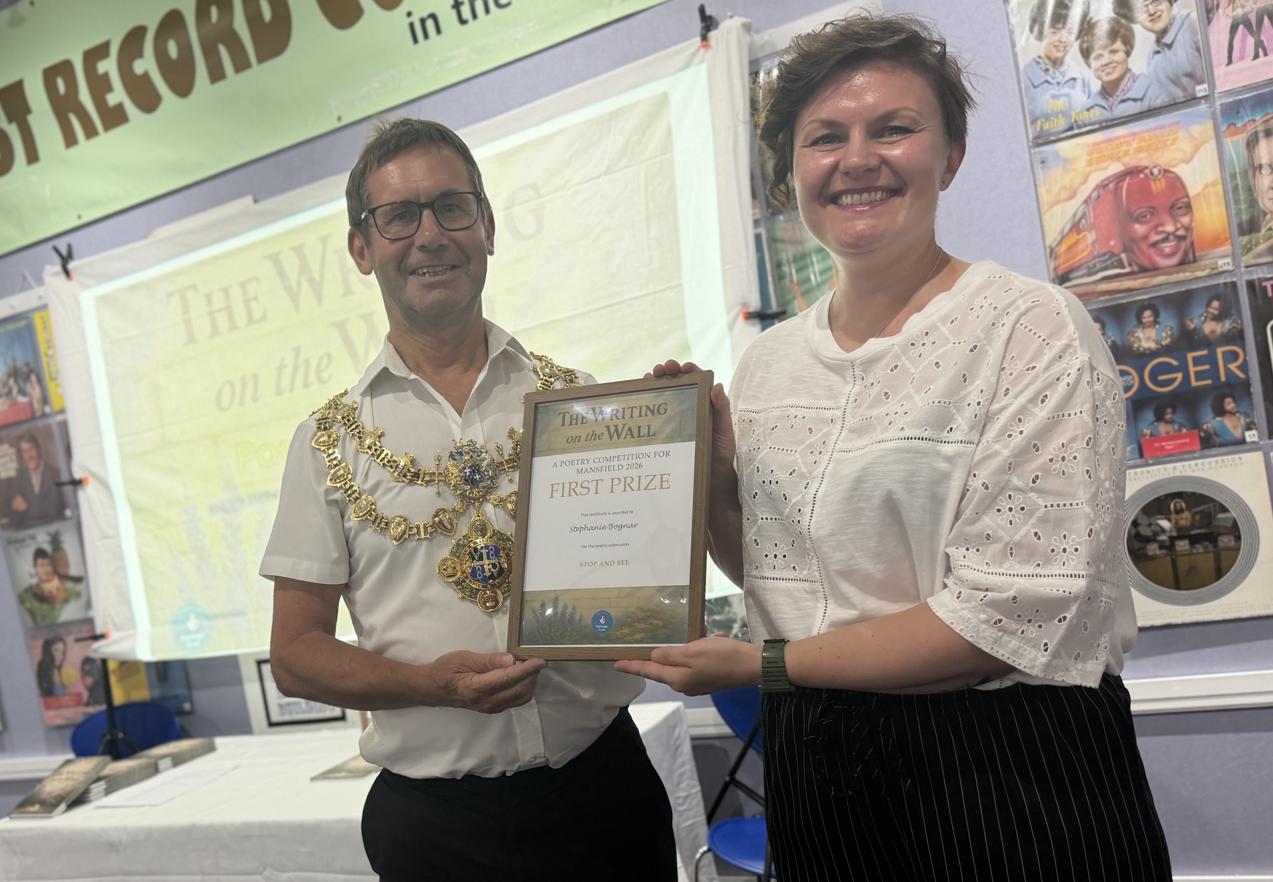 Mayor and winner holding certificate saying winner