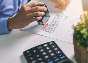 An image of a calculator and a man with a stamp