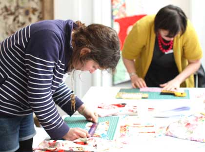 Two women doing craft activities at a table