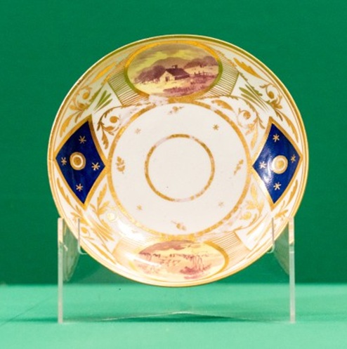 Saucer with dark blue and gilt border, and panels with landscapes