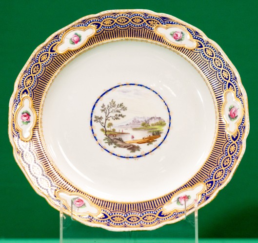 Plate with gilt and painted border, and landscape in centre