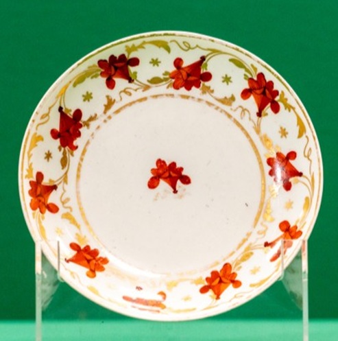 Ceramic saucer with a border of red flowers and gilt leaves