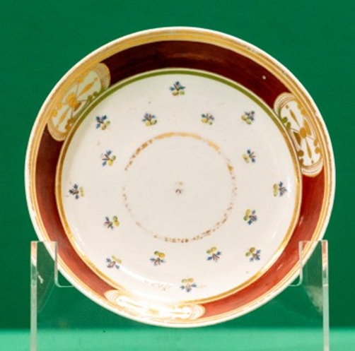 Saucer with red and gilt border, and tiny blue flowers