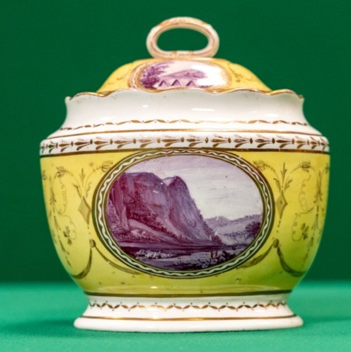 A lidded ceramic pot with landscapes in purple