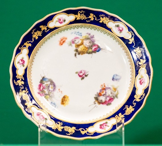Plate with gilt and painted border, and three sprigs of flowers around centre