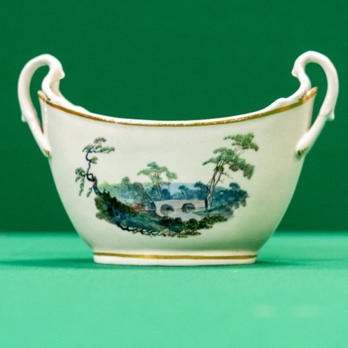 A boat-shaped vessel decorated with a landscape