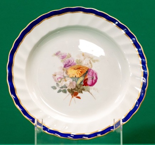 Plate with blue and gilt edge, decorated with a bunch of flowers