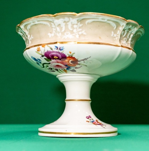 Elaborate ceramic dish with a stem and foot, decorated with flowers