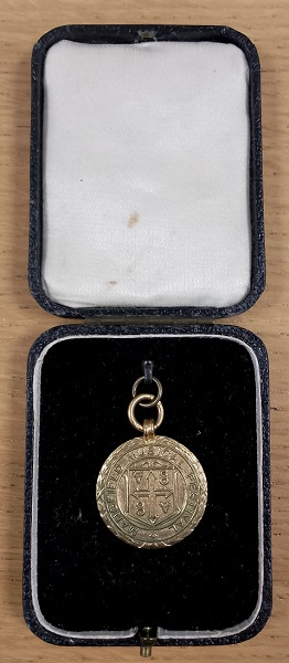 A gold medal in a presentation box