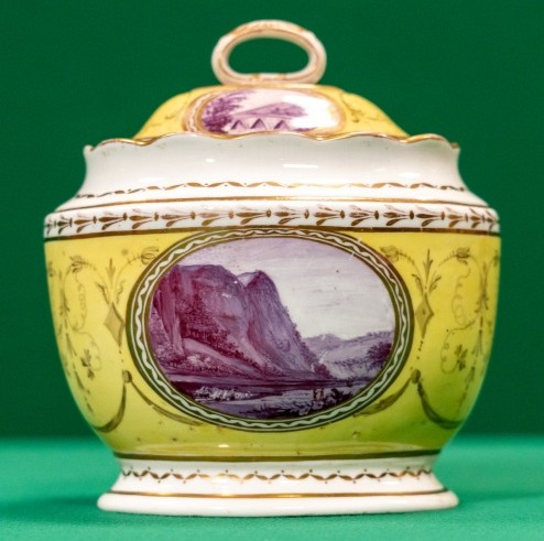 A lidded ceramic pot decorated with landscapes