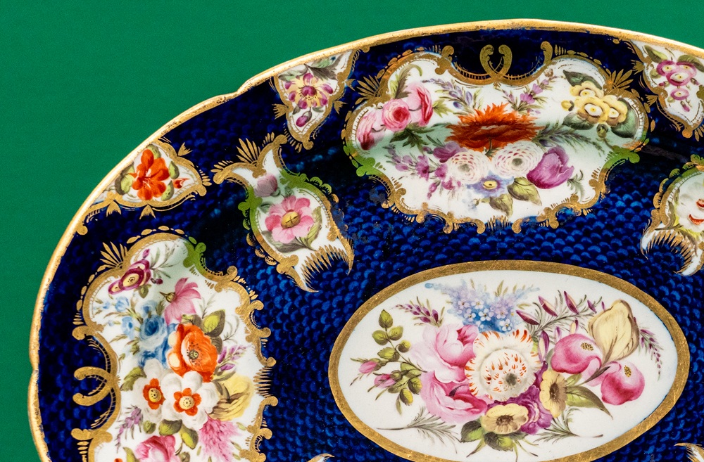 Detail of a porcelain platter decorated with panels of flowers on a blue background