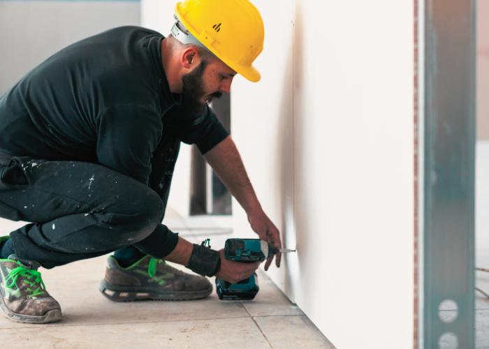 man in work gear using a drill