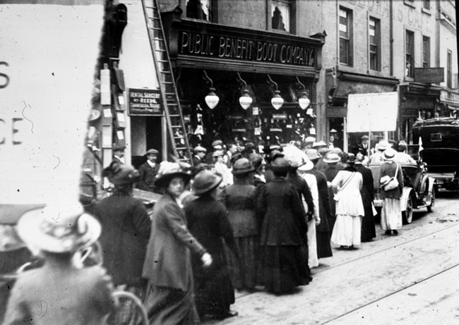 Suffragists processing along a city street