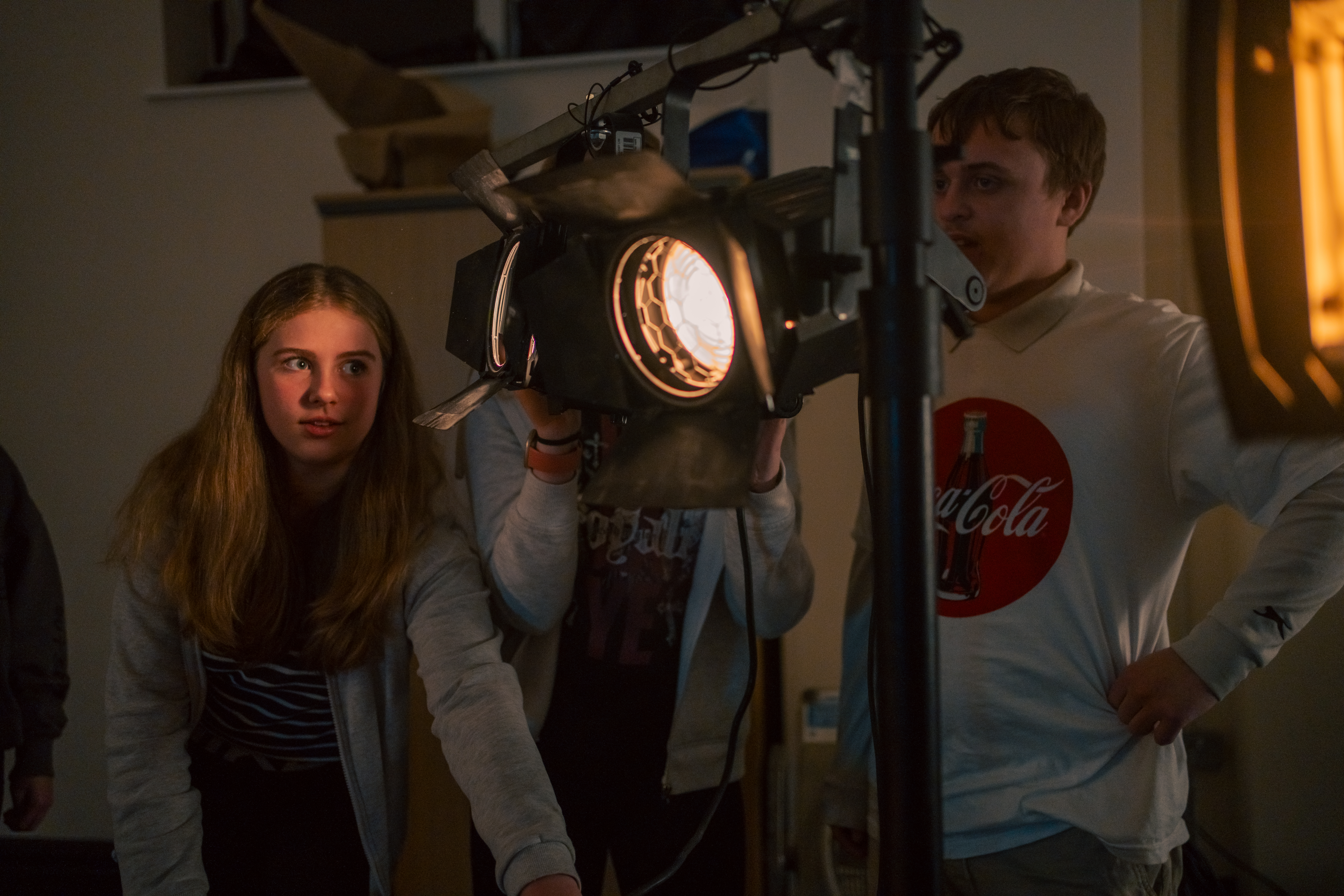 An Image of three young people using a theatre lantern.