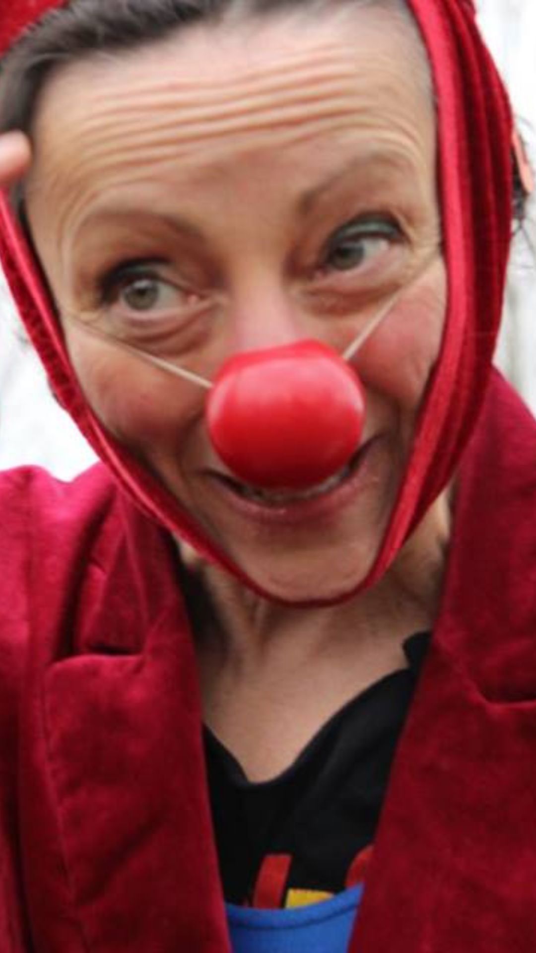 image of a lady wearing a red rose and smiling